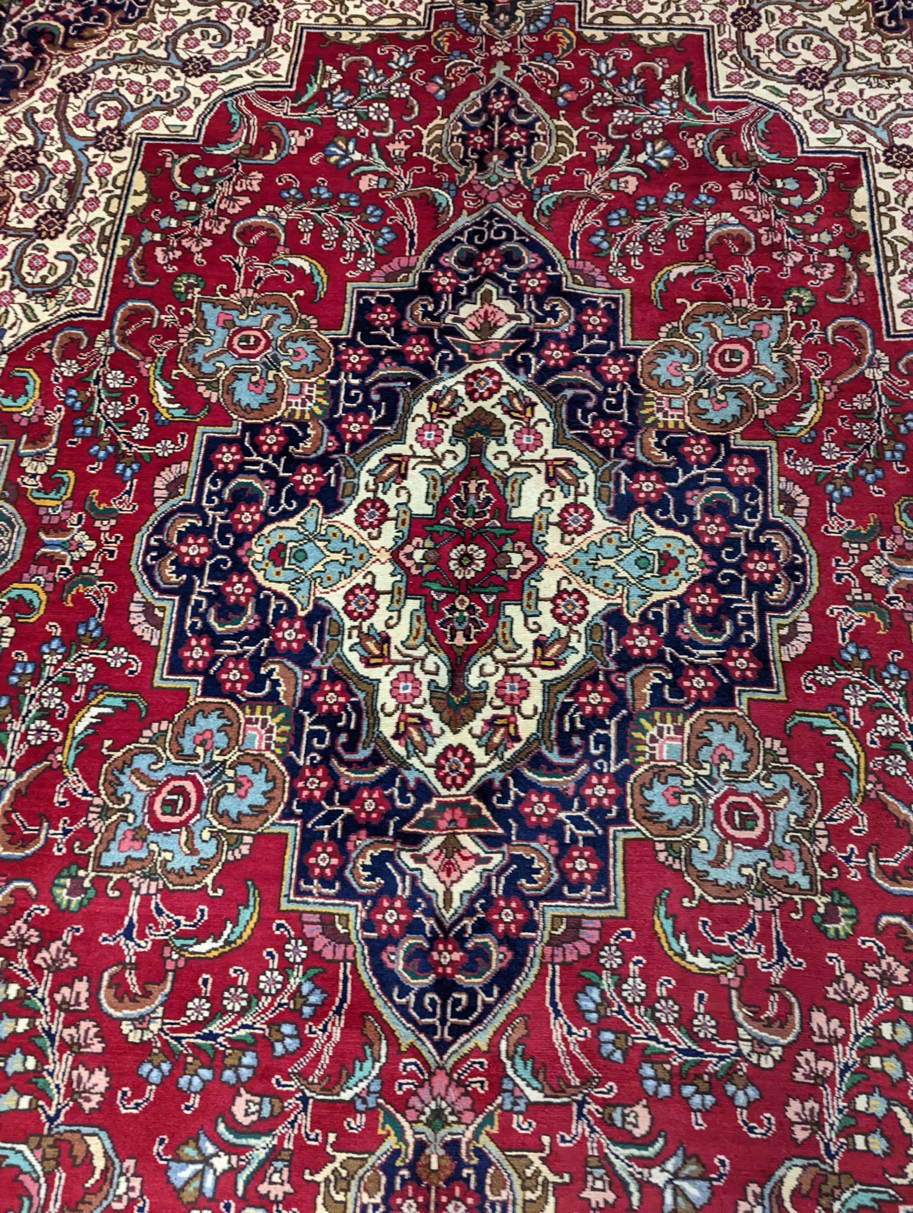 A Tabriz red ground carpet, 405 x 292cm